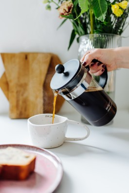 Lavazza Kaffe wird in Keramiktasse geschüttet 