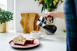 Lavazza Kaffe wird in Keramiktasse geschüttet 